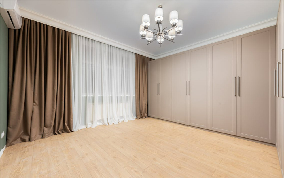 Large room with brown closets and drapery